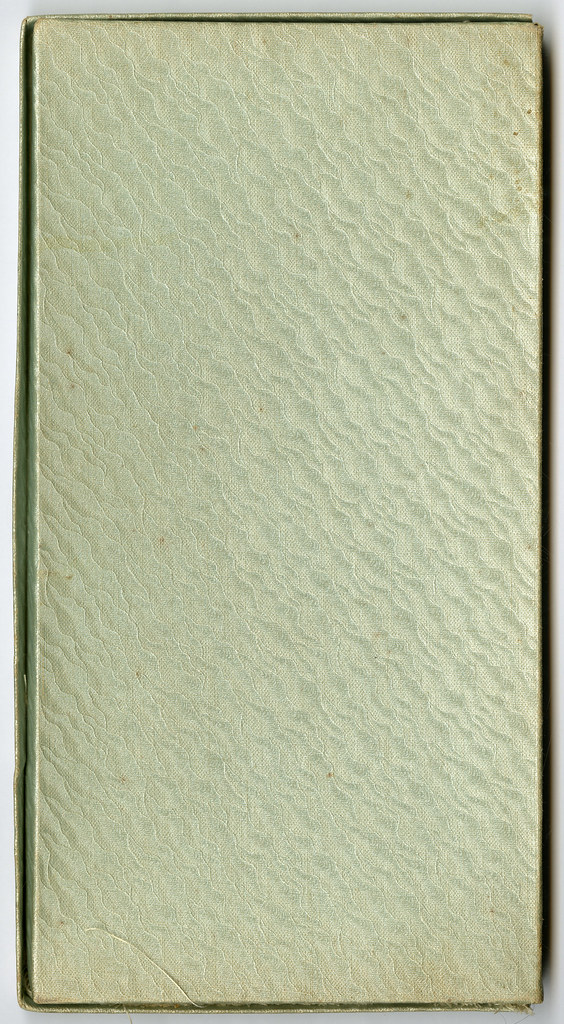 A closed, textured green book cover with no visible writing or design elements.